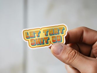 Let That Shit Go stress relief sticker on white headphones