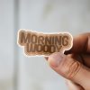 Man holding Morning Woody bachelor party sticker