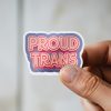 Man holding Proud Trans inclusivity advocacy sticker