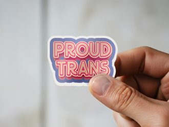 Man holding Proud Trans inclusivity advocacy sticker