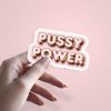 Woman holding Pussy Power women's rights sticker