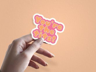 Woman holding You're The Tits thank you sticker
