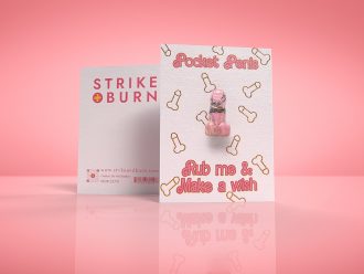 Pocket Penis good luck card with removable crystal penis charm and gold foil accents shown front and back on colorful background